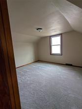 Empty, carpeted room with off-white walls and a single window letting in natural light at 701 S Roche Street. The view from the doorway highlights minimal furniture or decor—a bright opportunity in Knoxville real estate.