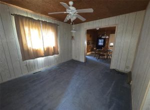 entry room next to the dining room with blue carpet, one window, and a ceiling fan